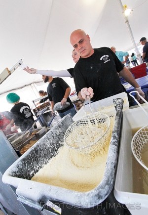 Manny Correia, owner of the Seafood Hut in Acushnet, batters up some scallops and shrimp for hungry folks attending the 12th annual Working Waterfront Festival Sunday afternoon. MICHAEL SMITH/STANDARD TIMES SPECIAL/SCMG